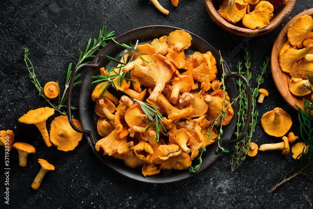 Chanterelle mushrooms in a bowl. Organic forest food. Top view. On a stone background. - obrazy, fototapety, plakaty 