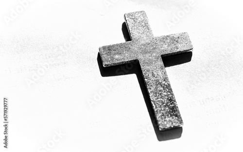Black and white picture of a metal chrisitian relgious cross against a white background. Includes ad space in the image.  photo