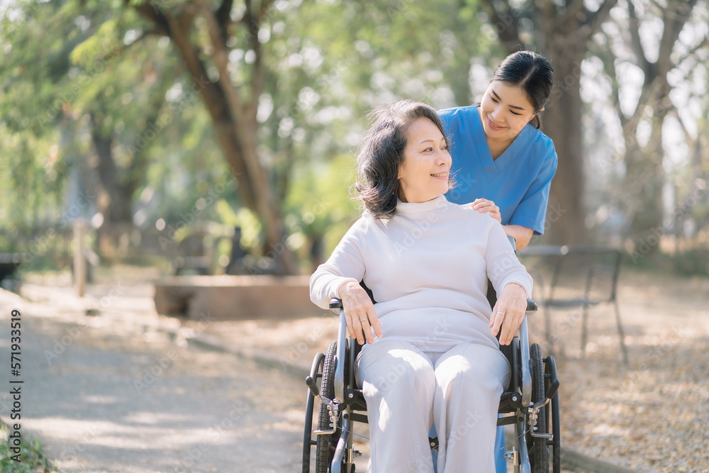 Smiling physiotherapist taking care of the happy senior patient in wheelchair, outdoor. Smiling physiotherapist taking care of the happy senior patient in wheelchair, outdoor.
