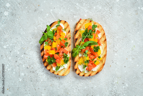 Vegan Sandwich with sweet peppers, cheese, vegetables and basil. Bruschetta. Top view. On a stone background.