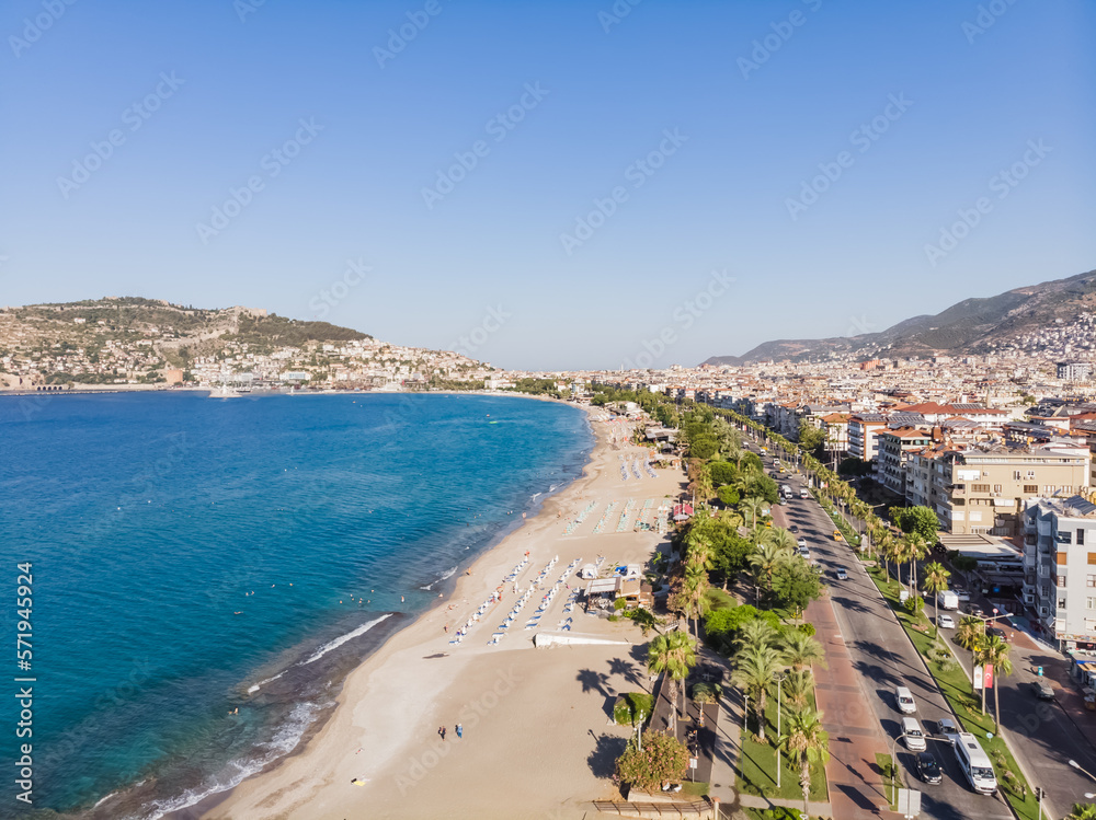 Coastline with beach, top view of the tourist city of Alanya in Turkey and the blue sea, on a sunny summer day