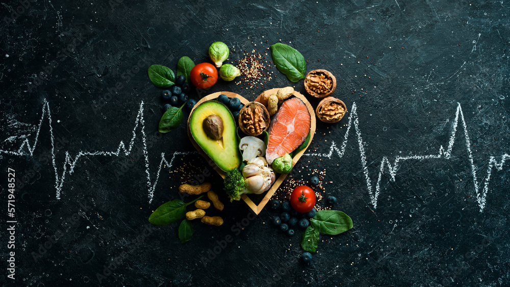 Food banner. Healthy foods low in carbohydrates. Food for heart health: salmon, avocados, blueberries, broccoli, nuts and mushrooms. On a black stone background. Top view. - obrazy, fototapety, plakaty 