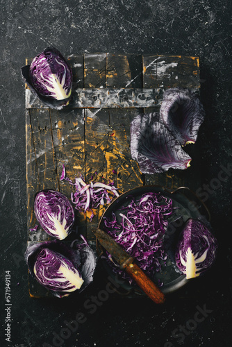 Autumn vegetables. Fresh sliced purple cabbage in a metal tray. On a black stone background.