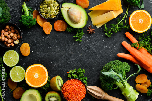 Set of vegetables  fruits and food on a black stone background. Foods are rich in vitamin A. Top view. Free space for your text.