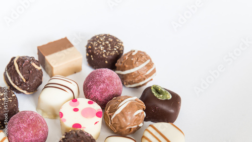 Chocolate pralines truffles with empty space for text.
Selection round truffles confection design for Birthday gift. Luxury candies in white background. Assortment of colorful milk chocolate with nuts