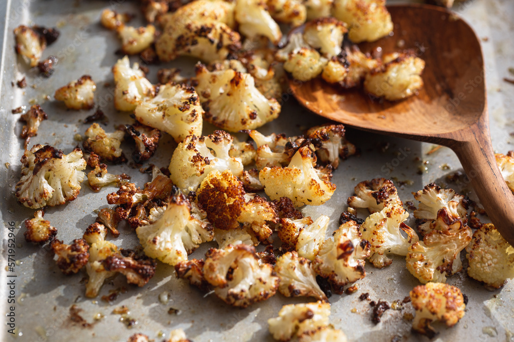 Roasted cauliflower florets in the oven on a baking sheet pan Roasted cauliflower florets in the oven on a baking sheet pan