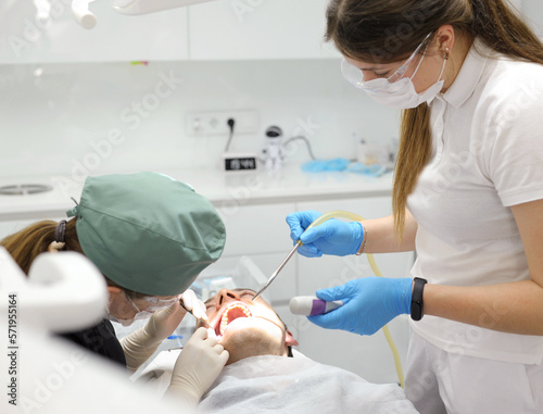 in the dental office, a dentist and his assistant perform an operation to remove high wisdom teeth concept of surgery in dentistry instruments surgery dentistry clinic
