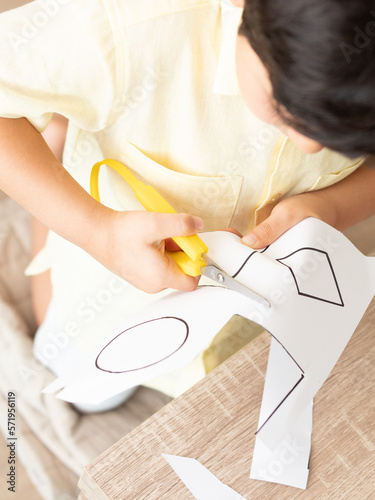 Boy cutting with an adapted scissor lines and shapes