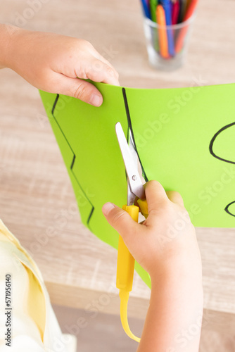 Boy cutting with an adapted scissor lines and shapes