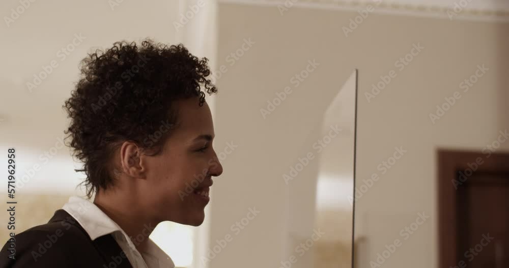 Content ethnic woman smiling at reception desk in hotel