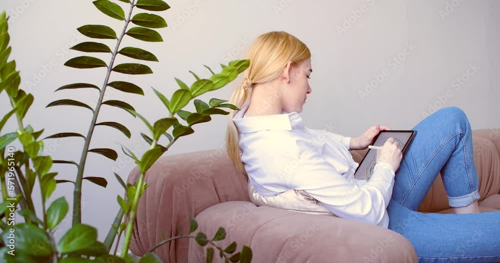 A talented female artist draws a beautiful image on the digital pad screen. A talented female artist draws a beautiful image on the digital pad screen.