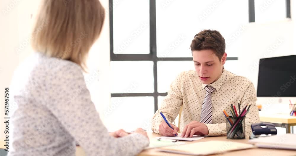 Dealer visits client at desk in office Dealer visits client at desk in office