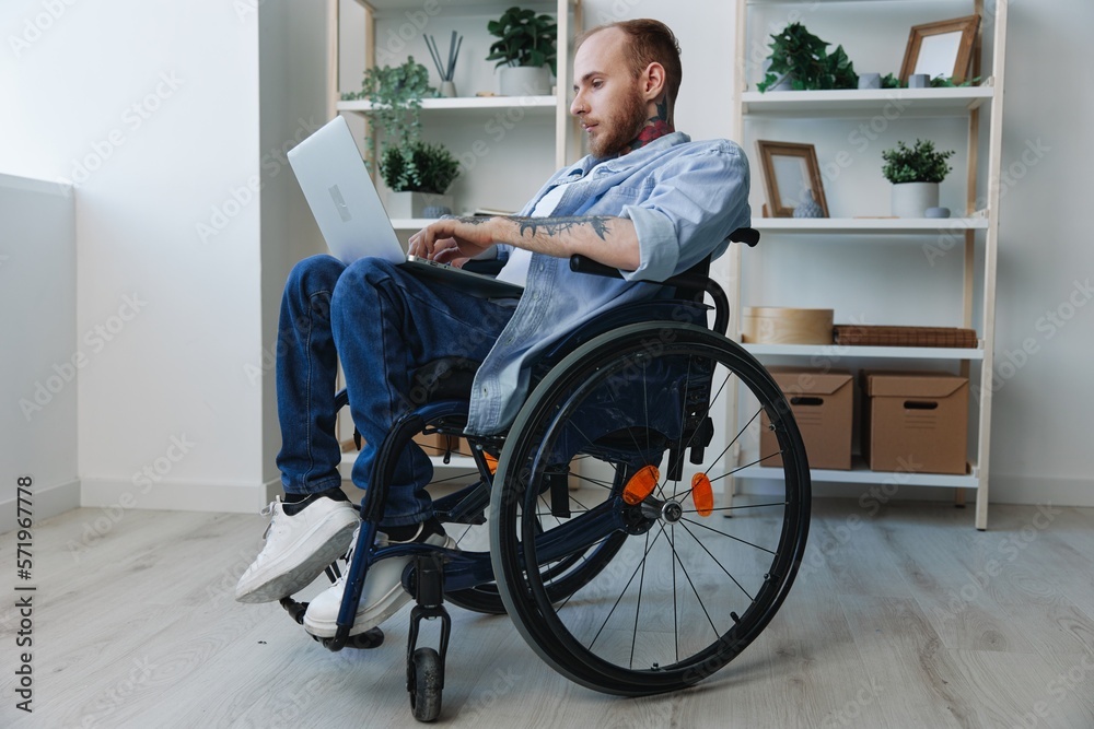 Man wheelchair freelancer working at laptop at home smile, working online, social networks and startup, copy space, integration into society, health concept man with disabilities, real person close-up Man wheelchair freelancer working at laptop at home smile, working online, social networks and startup, copy space, integration into society, health concept man with disabilities, real person close-up
