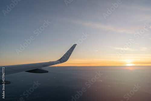 Beautiful sunset, sky on the top view, airplane flying view from inside window aircraft of Traveling.. Sunlight and flare background concept.