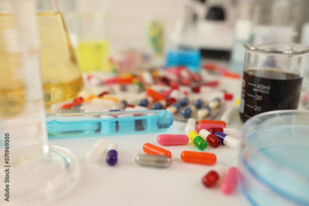 Colored capsules and test tubes on the table in laboratory Colored capsules and test tubes on the table in laboratory