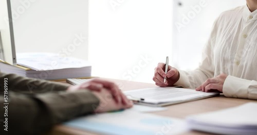 Woman studies and signs contract or agreement after interview photo