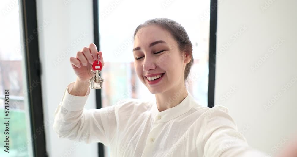 Cheerful happy girl takes selfie and holds house keys Cheerful happy girl takes selfie and holds house keys