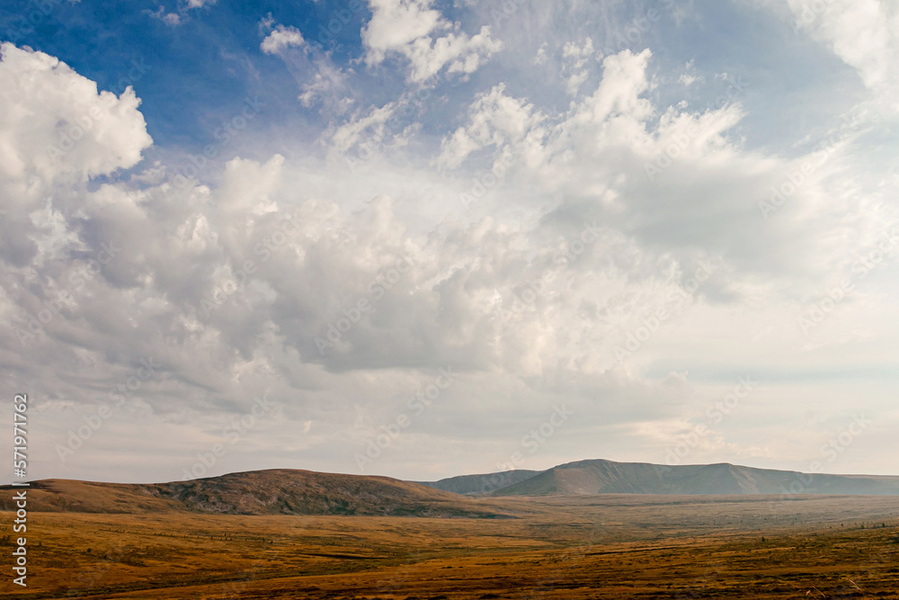 Altai mountain valley autumn withering grass. blue sky with white clouds Altai mountain valley autumn withering grass. blue sky with white clouds