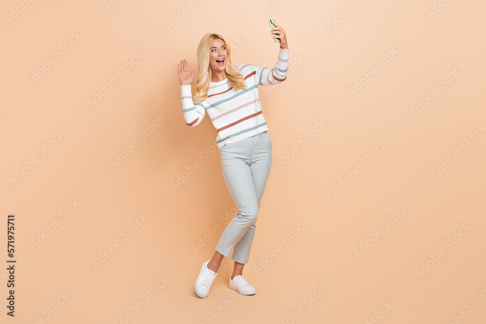 Full size photo cadre of mature age blonde hair lady palm shaking hello symbol smartphone video conference isolated on beige color background