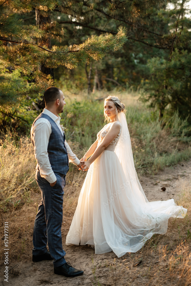 the groom and the bride are walking in the forest