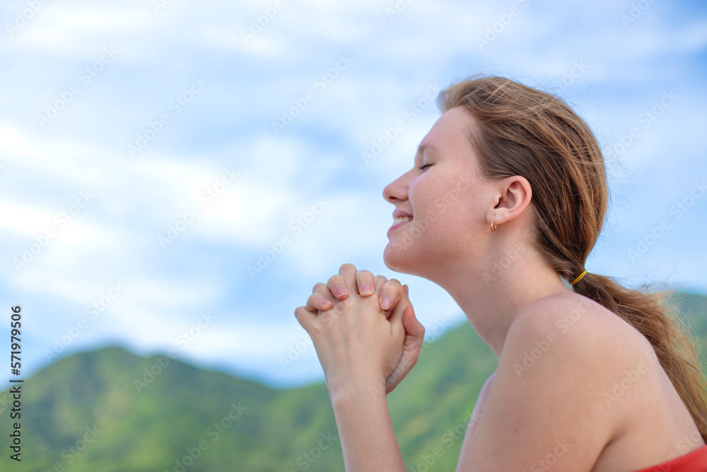 Portrait of happy beautiful young girl, dreams and meditation, relax nature, tanning on sun at summer sunny day on natural background with sky and mountains, breathing deep fresh air Portrait of happy beautiful young girl, dreams and meditation, relax nature, tanning on sun at summer sunny day on natural background with sky and mountains, breathing deep fresh air