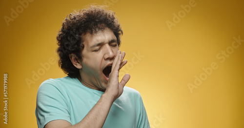 Photography Young asian man with curly hair in casual clothes beind tired or bored, yawning