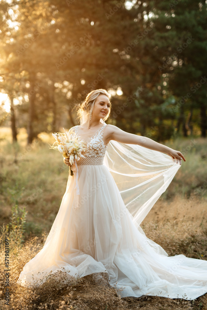 bride blonde girl with a bouquet in the forest