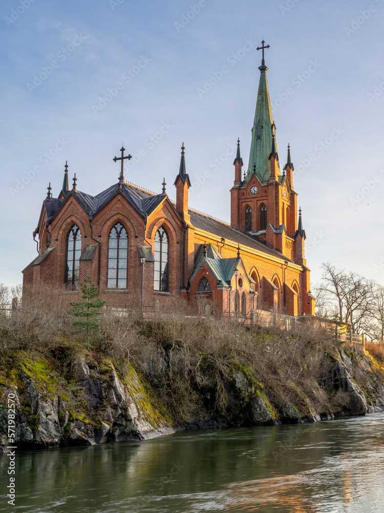 Majestic old-fashioned Gothic Revival Church, Trollhattan Church during sunlit sunset in midtown of Trollhattan city Sweden.