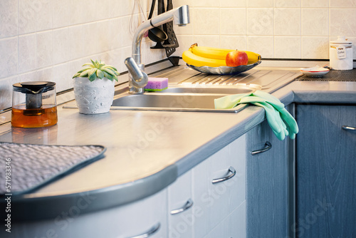 Kitchen after cleaning. Daily washing and cleaning with protective equipment. Sponge for washing sink and rubber gloves to protect skin of hands. Сoncept housekeeping Selective focus.