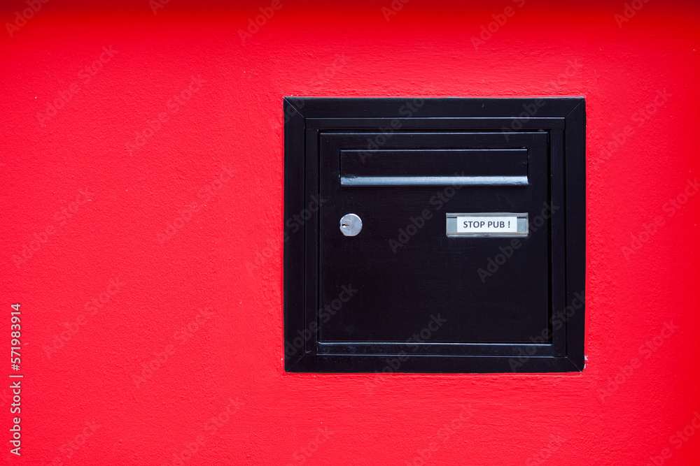 Black mailbox incrusted in a red wall Black mailbox incrusted in a red wall