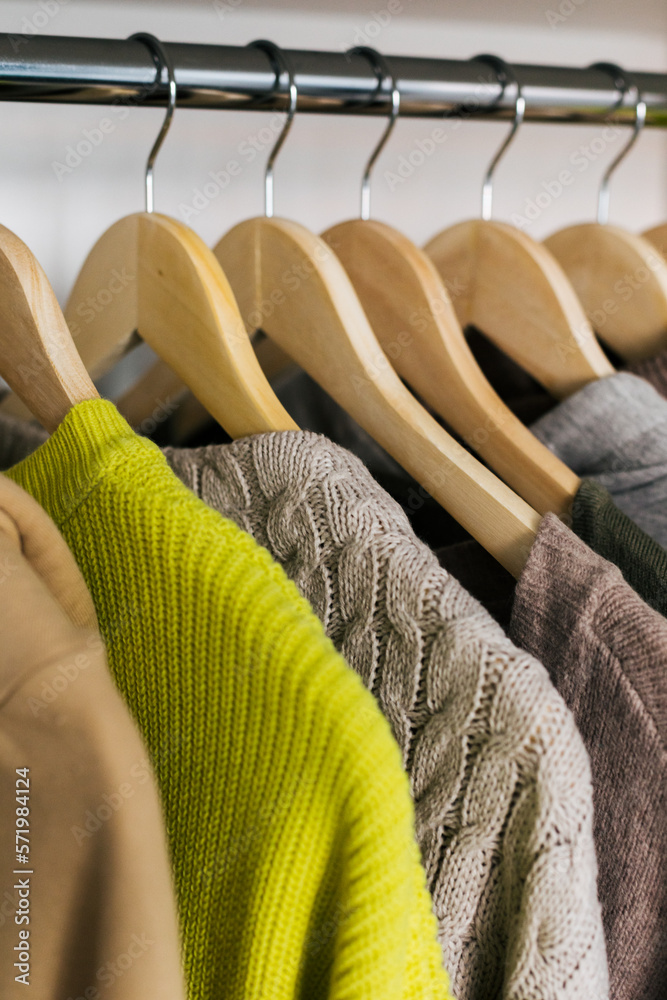 Obraz premium The basic wardrobe of a fashion stylist. Neutral colors: white, brown, beige, grey. Bright colors: yellow. White wardrobe, wooden hangers and towels