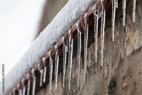 Foto Ice stalactites at the edge of a wall