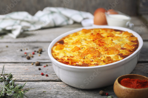 French cuisine. Vegetable pumpkin clafoutis in ceramic bakeware, smoked paprika dressing, eggs and cream