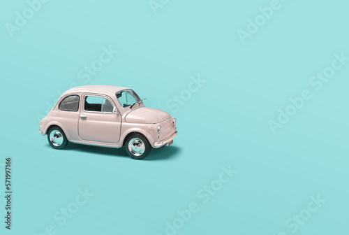 Fotografía Miniature pale pink toy car on green background with copyspace