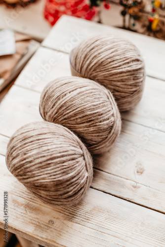 Three coils of soft woolen threads on a wooden background side view
