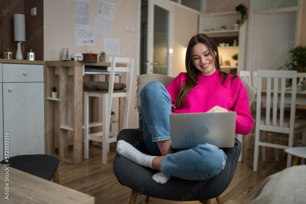 One young woman use laptop computer at home while sit comfortable One young woman use laptop computer at home while sit comfortable