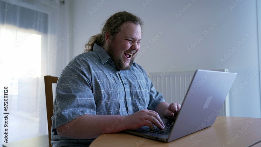 One happy overweight celebrating GREAT news in front of laptop. Over excited person dancing of joy using computer celebrates success One happy overweight celebrating GREAT news in front of laptop. Over excited person dancing of joy using computer celebrates success