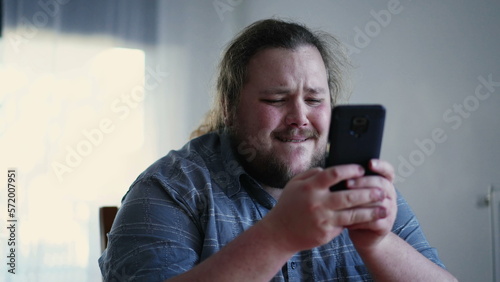 Joyful guy holding phone liking content online. Happy emotion of male casual person feeling excitement