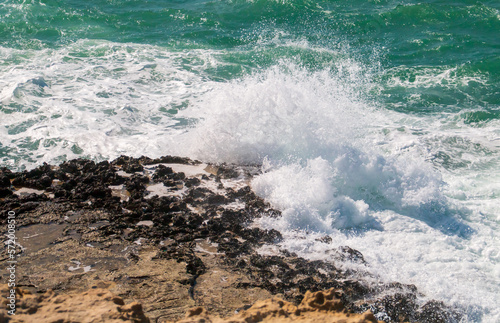 Olas rompientes en la costa de Roca Vecchia en Lecce, Italia. Salpicaduras de las olas de un mar Adriático azul turquesa rompiendo contra los acantilados calizos en un soleado día de verano. photo