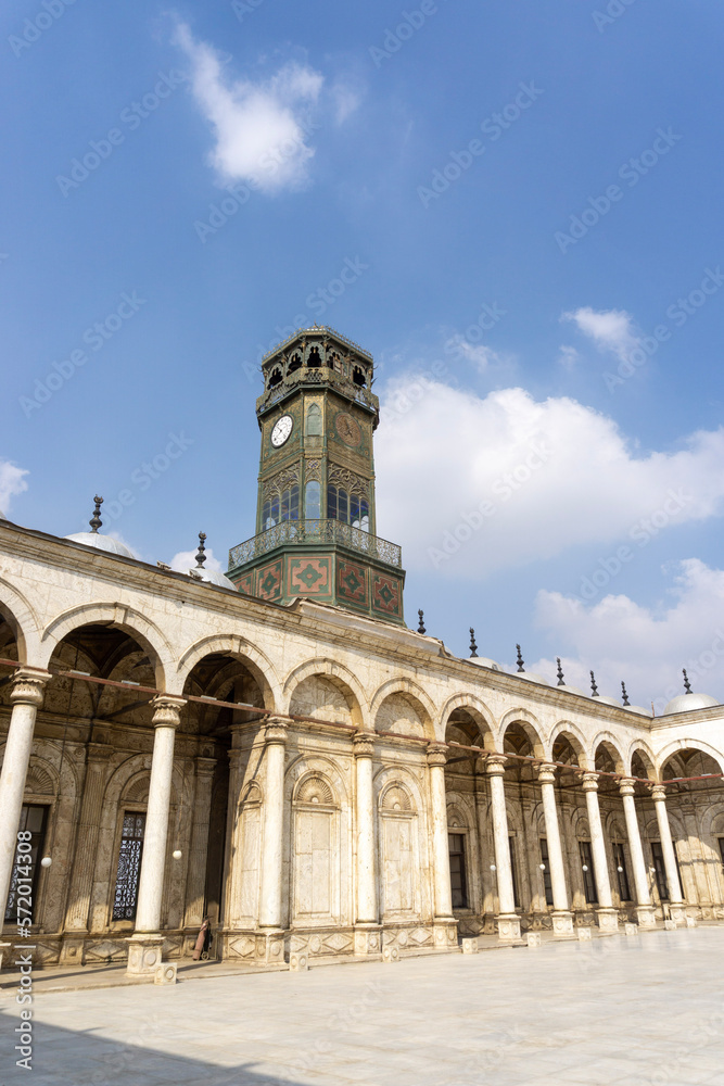 Courtyard of the Alabaster Mosque, with the clock tower, on a sunny day.