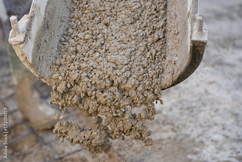 Concrete can be seen falling to the ground from a pipe.