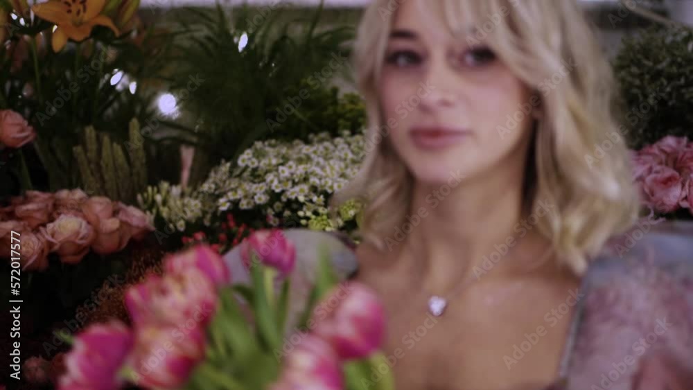 beautiful girl playing with the flower. pretty girl with the flower in flower shop