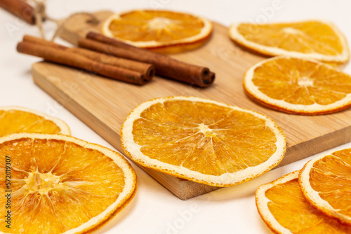 Dry orange slices on a board. Cinnamon sticks. Close up.