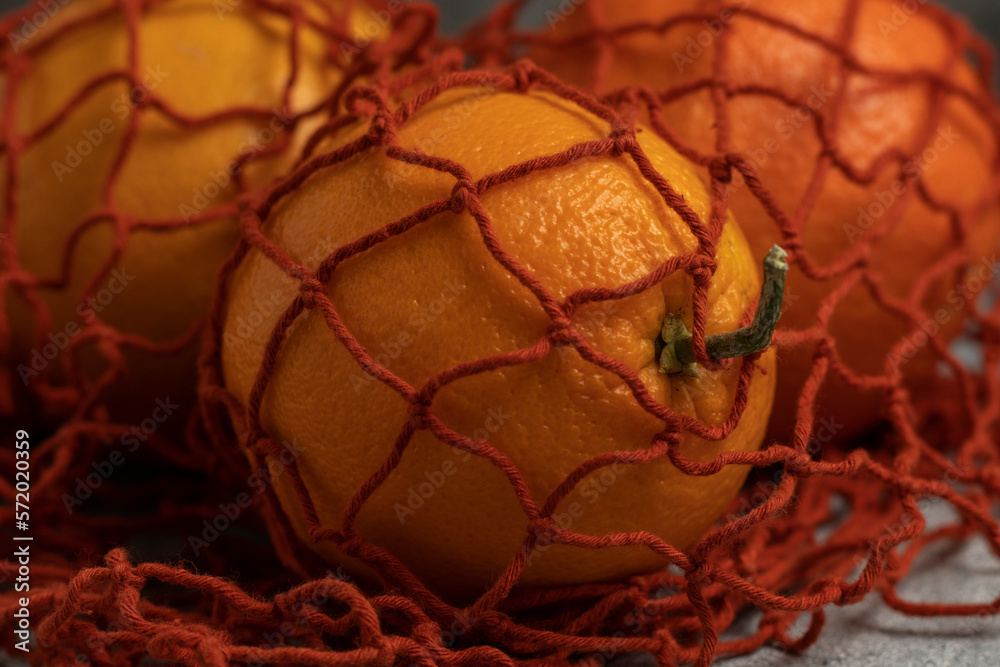 Red net shopping bag with oranges. Close up. Red net shopping bag with oranges. Close up.