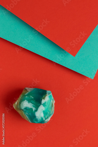 Turquoise handmade soap on red and blue background. Top view.