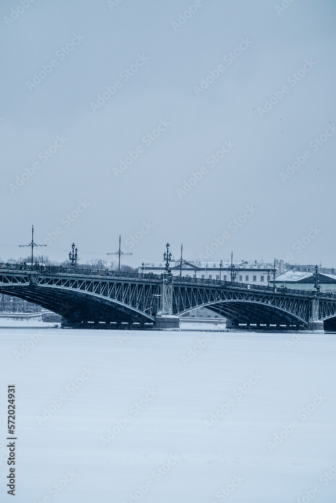 Fototapeta premium Bridge over the river and embankment in winter in a big city.