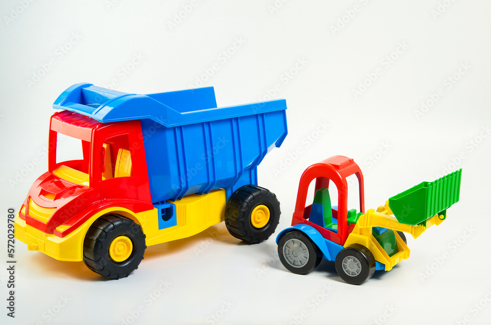 Children's toy plastic excavator and truck on a white background. Children's toy plastic excavator and truck on a white background.