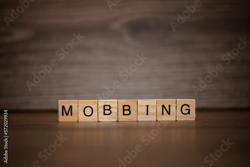 The word mobbing is made up of wooden cubes tablets on a dark wooden background