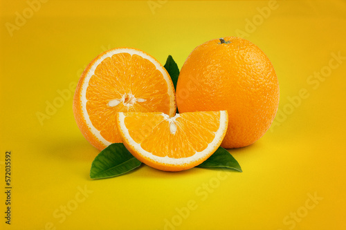 Oranges with green leaves in yellow background