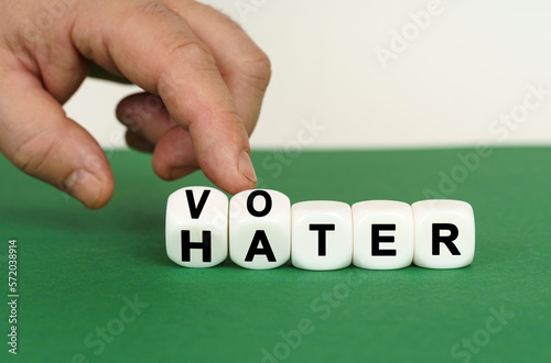 On a green surface are white cubes with the inscription - VOTER or HATER